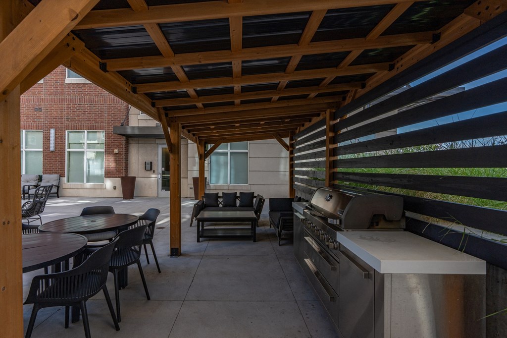 a covered patio with a grill and tables and chairs at 200 City View, Provo, UT, 84601