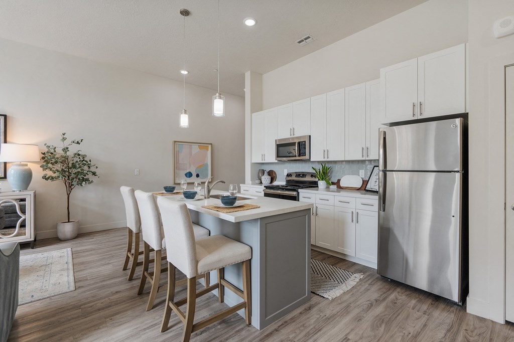 an open kitchen and dining area with a stainless steel refrigerator at 200 City View, Provo