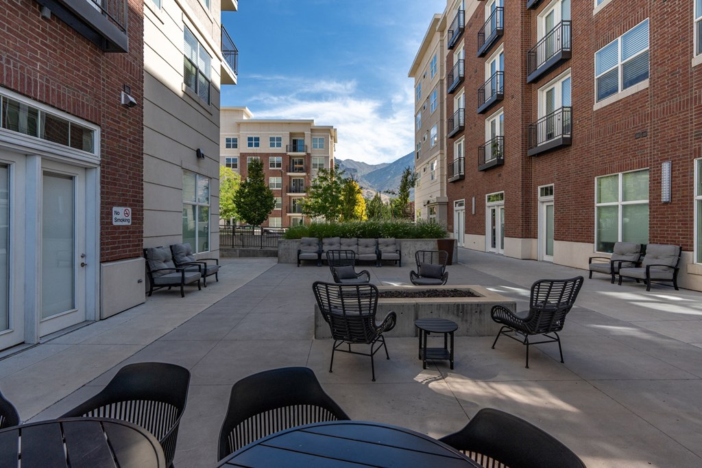 an outdoor patio with tables and chairs and a fire pit at 200 City View, Provo, UT