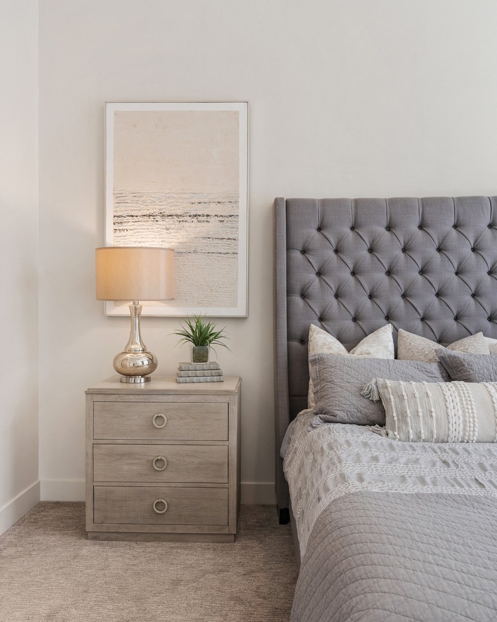 a bedroom with a bed with a tufted headboard and a night stand at 200 City View, Utah