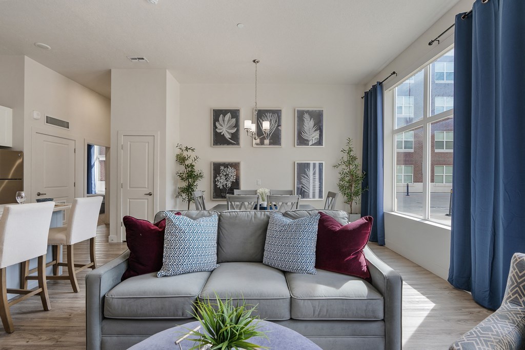 a living room and dining room with a couch and a table and chairs at 200 City View, Provo, UT, 84601