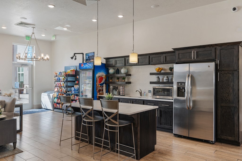 a kitchen with stainless steel appliances and a bar with three stools at 200 City View, Provo