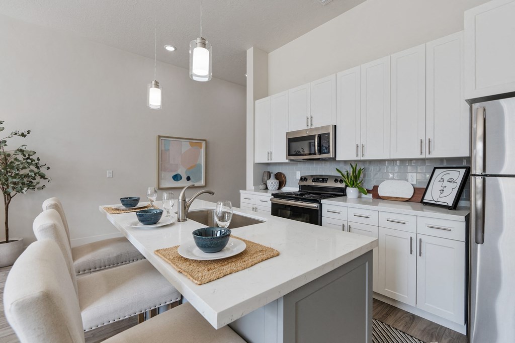an open kitchen and dining area with white cabinets and stainless steel appliances at 200 City View, Provo, UT, 84601