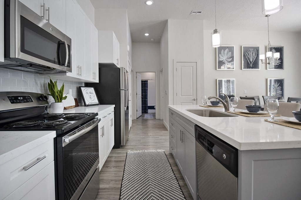 a kitchen with white cabinets and a black and white rug at 200 City View, Provo, UT, 84601