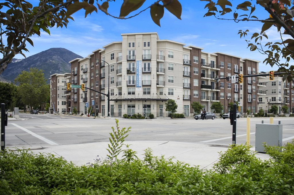 an empty street in front of an apartment building with a mountain in the background at 200 City View, Provo, UT, 84601