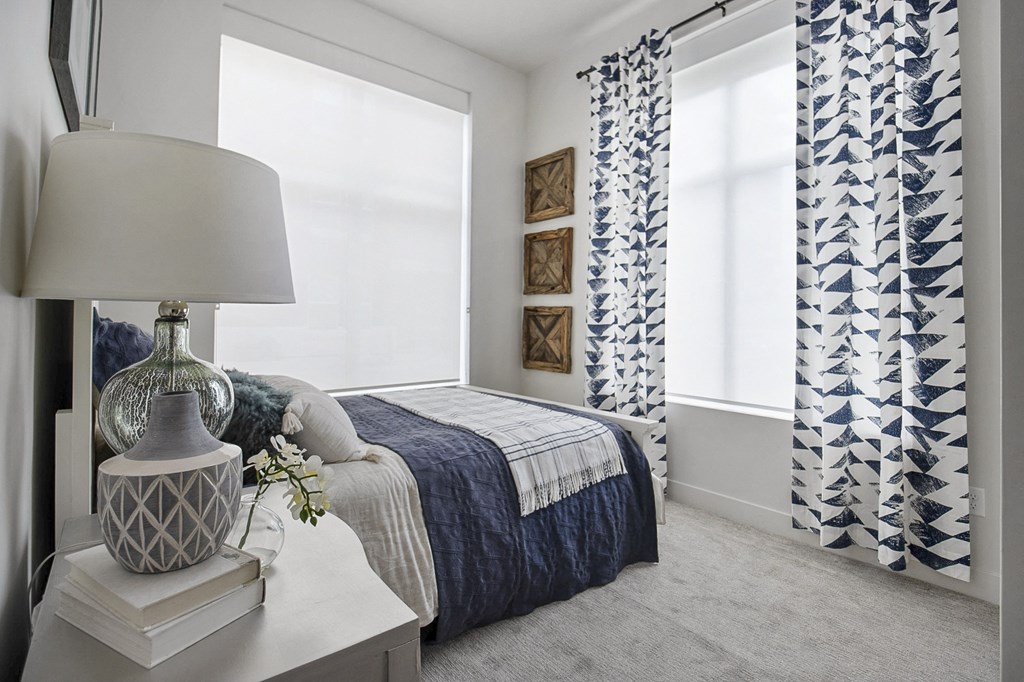 a bedroom with two windows and a bed with blue and white bedding at 200 City View, Provo, Utah