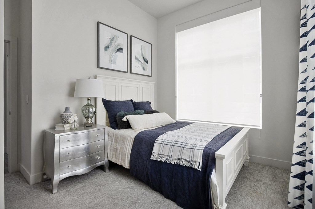 a bedroom with a bed and a dresser with a lamp on it at 200 City View, Utah, 84601