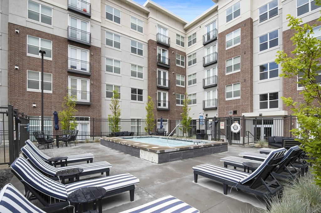 a courtyard with a hot tub and lounge chairs at the bradley braddock road station at 200 City View, Provo, Utah