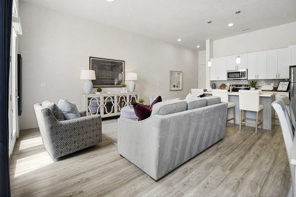 a living room and kitchen with hardwood floors and white cabinets at 200 City View, Provo, 84601