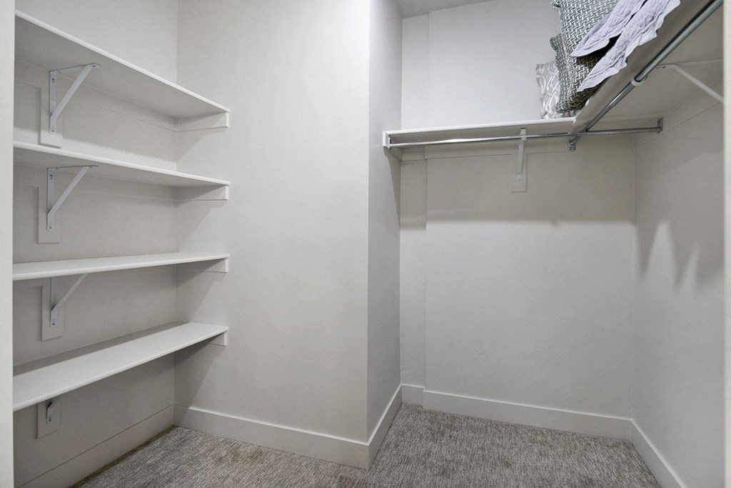 a walk in closet with white walls and white shelves at 200 City View, Utah