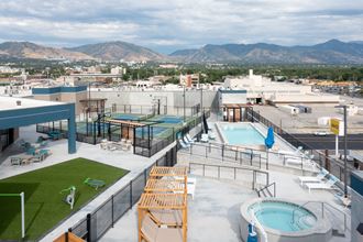 the pool on the roof of a building with mountains in the background