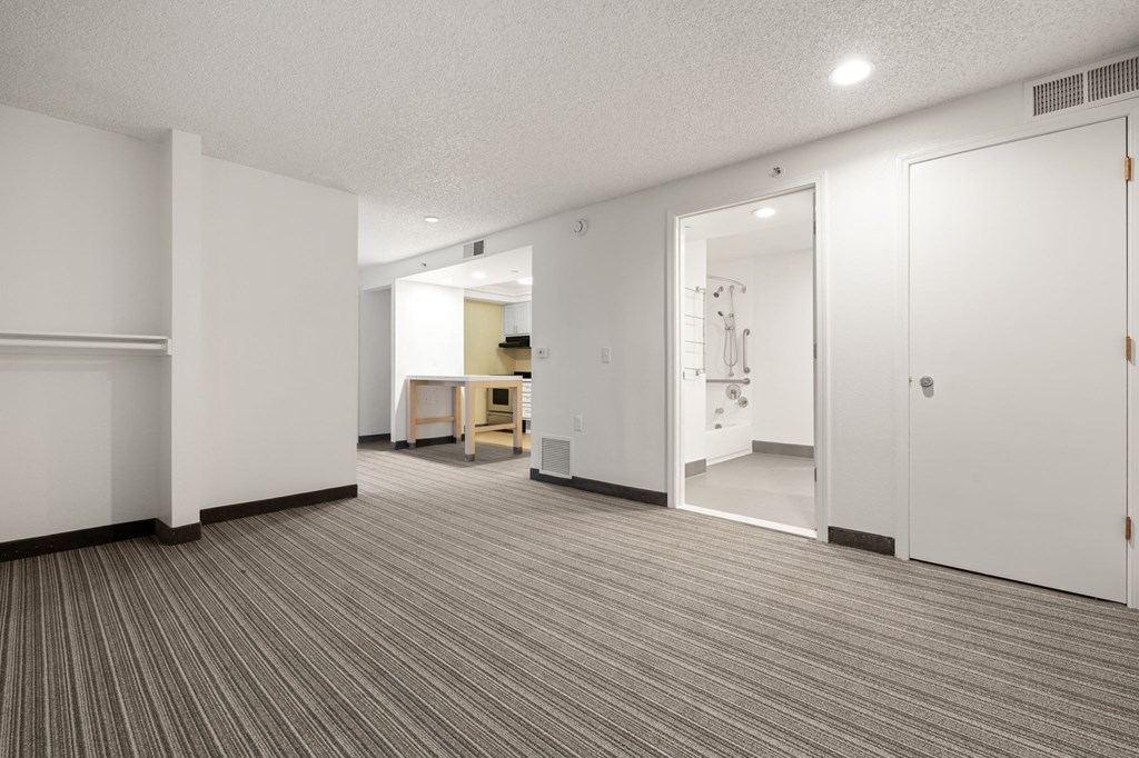 A room with a striped carpet and a white door. at AVIA Lofts on Parkway Apartments, Washington, 98662