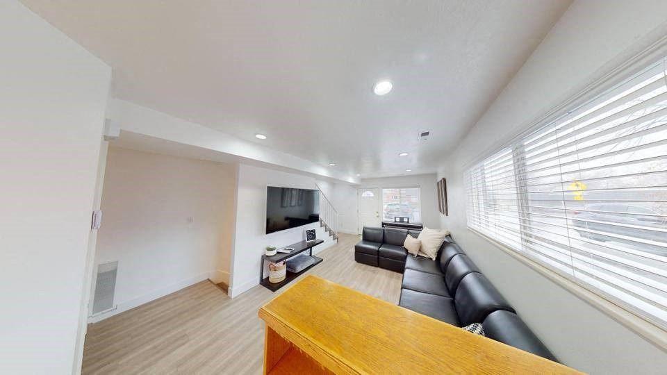 A living room with a couch, a television, and a wooden table.