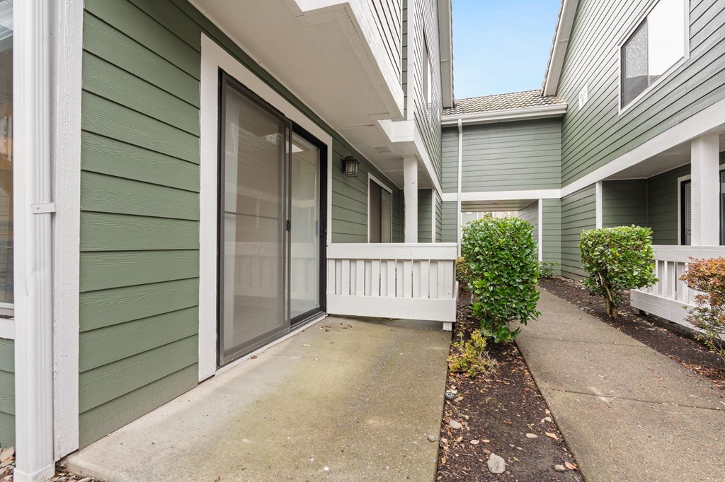 A green house with a white fence and a small garden. at AVIA Lofts on Parkway Apartments, Washington