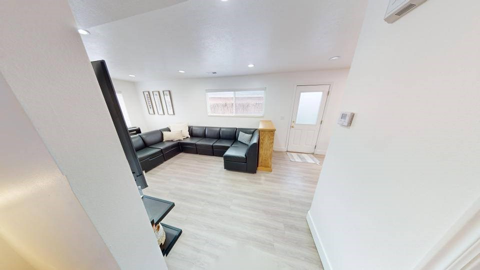A living room with a black couch and a wooden coffee table.