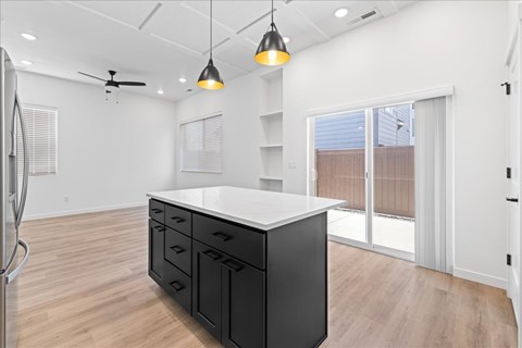 A kitchen with a white counter and black cabinets.at Alante Homes at Spring Run, Caldwell, ID