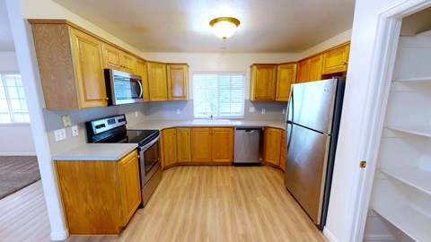 A kitchen with wooden cabinets and a refrigerator.
