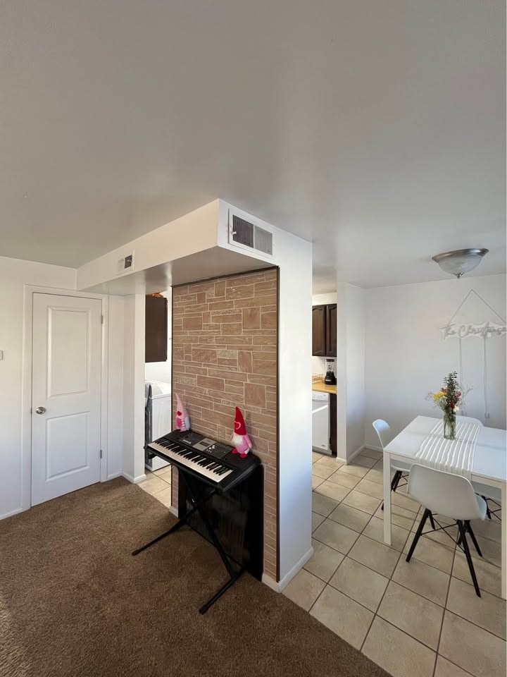 A room with a piano and a dining table.