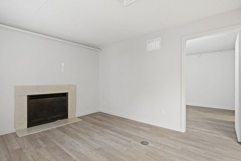 the living room of an apartment with a fireplace and wooden floors at AVIA Lofts on Liberty Ridge Apartments, Jacksonville 32256