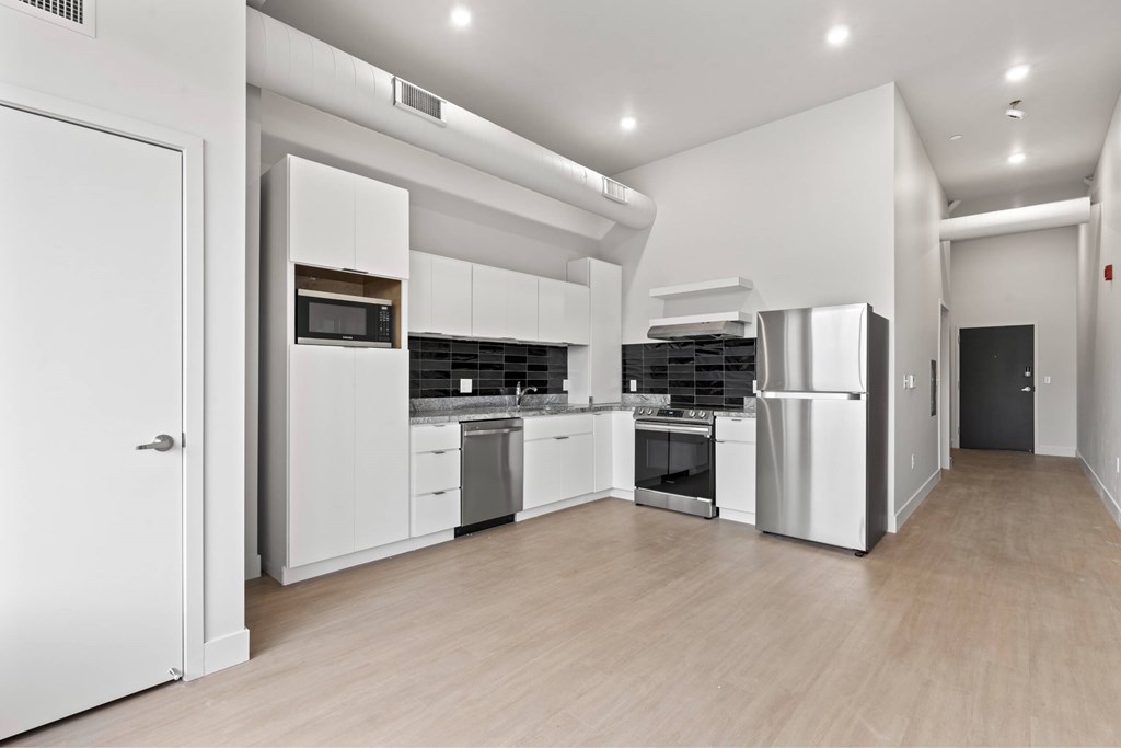 A modern kitchen with white cabinets and stainless steel appliances. at Brickside Heights, Millcreek, UT