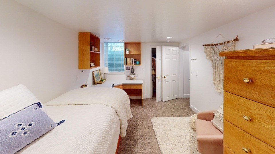 A bedroom with two beds and a dresser.