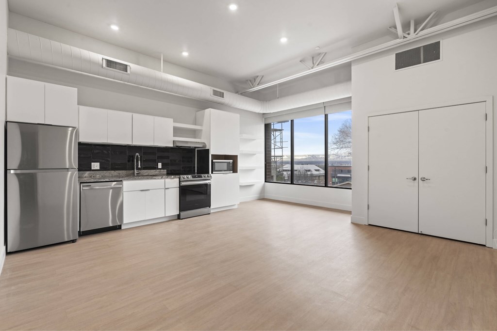 A modern kitchen with stainless steel appliances and white cabinetry. at Brickside Heights, Millcreek, UT
