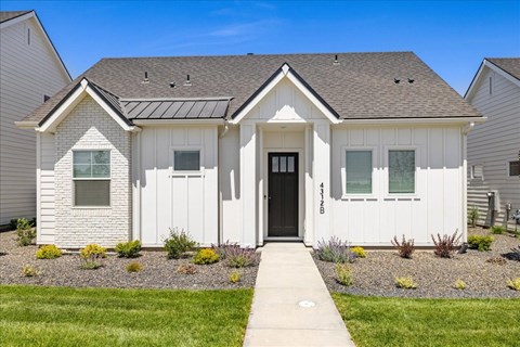 A white house with a black door and windows.at Alante Homes at Spring Run, Caldwell, ID 83607