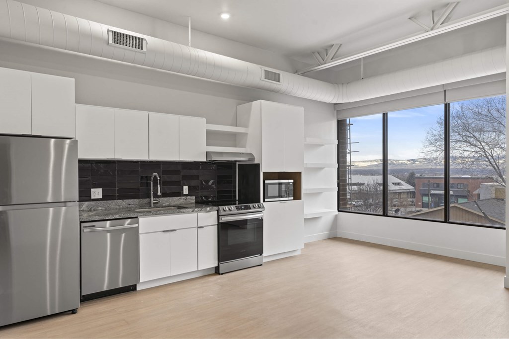 A modern kitchen with white cabinets and stainless steel appliances. at Brickside Heights, Utah