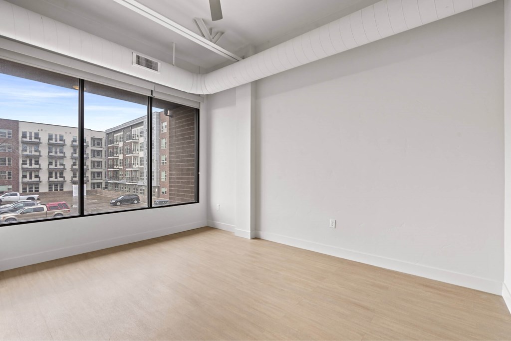 Empty room with a window overlooking a parking lot. at Brickside Heights, Millcreek, 84106
