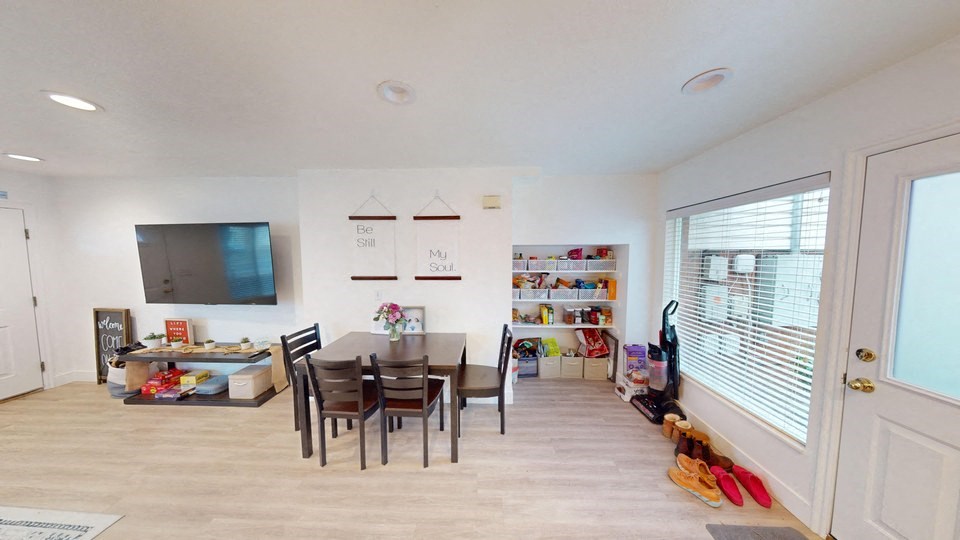 A dining room with a table and chairs.