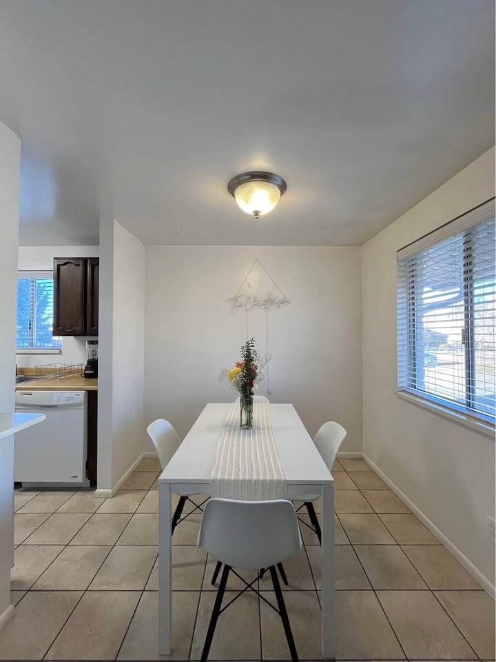 A dining room with a white table and chairs.