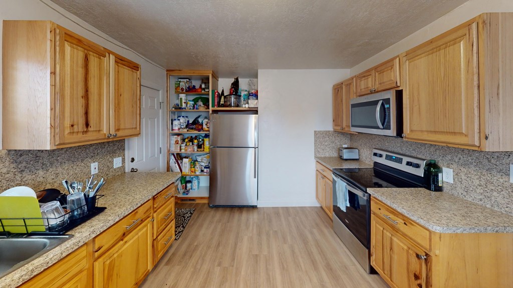 A kitchen with wooden cabinets and a granite countertop.