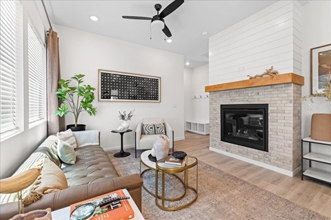 A living room with a fireplace and a couch.at Alante Homes at Spring Run, Caldwell, ID 83607