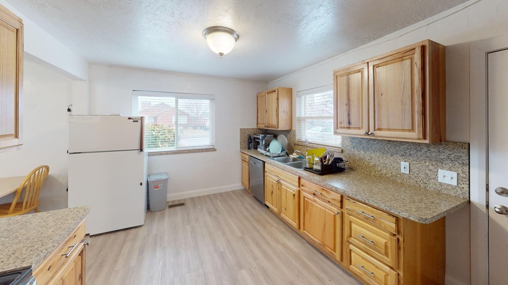 A kitchen with wooden cabinets and a granite countertop.