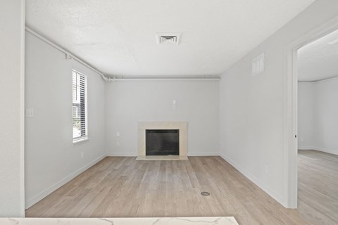 an empty living room with a fireplace and wooden floors at AVIA Lofts on Liberty Ridge Apartments, Florida, 32256