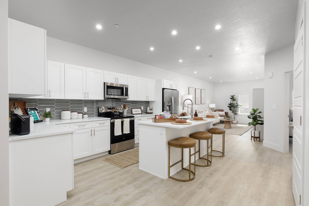 A modern kitchen with white cabinets and a central island.