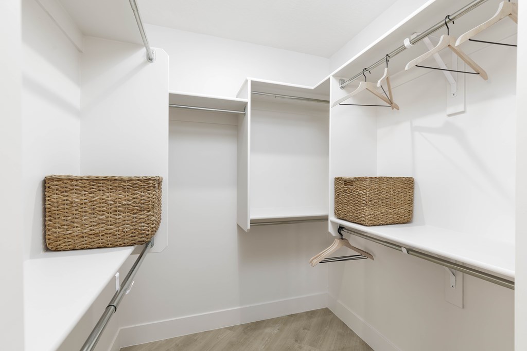 A white closet with a basket on the shelf.