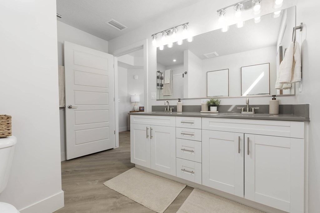 A white bathroom with a large mirror and a white toilet. at The Vue At Desert Color, St. George, UT, 84790