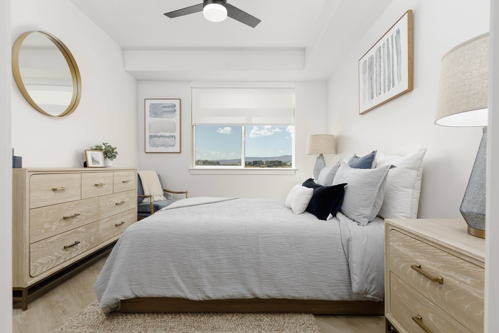 A bedroom with a bed, dresser, and window.