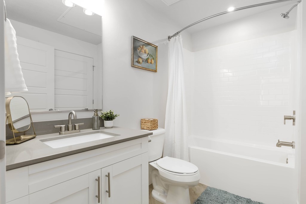 A white bathroom with a toilet, sink, and bathtub.