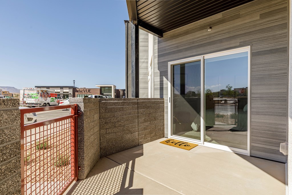 A modern house with a glass door and a red gate.