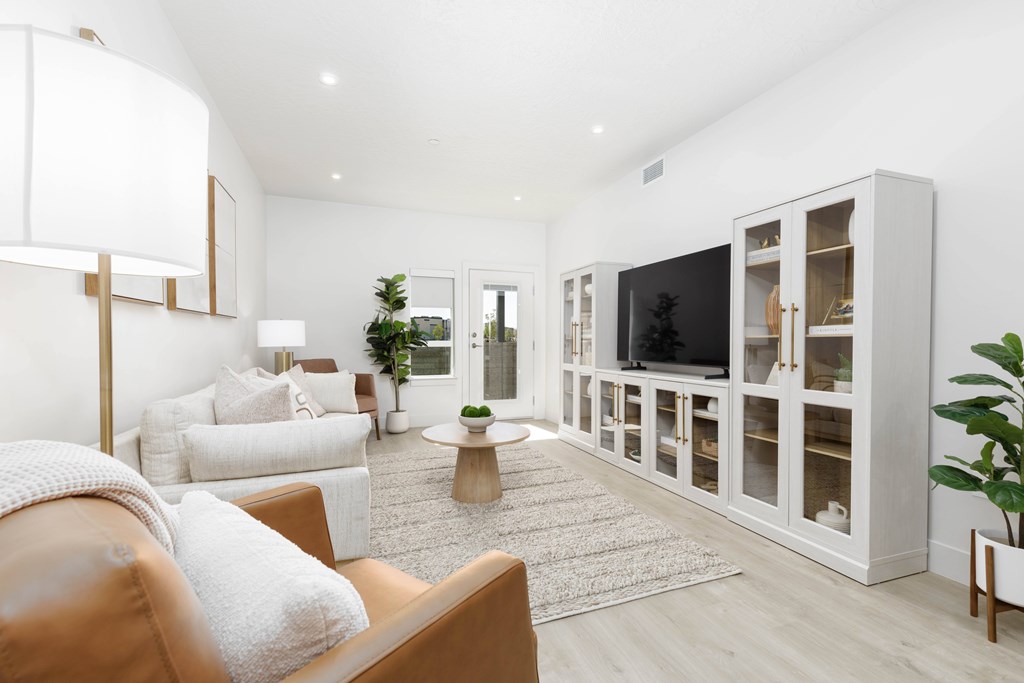 A living room with a brown leather couch and a white sofa.