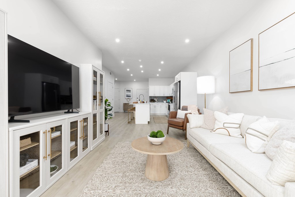 A modern living room with a white sofa and a wooden coffee table.
