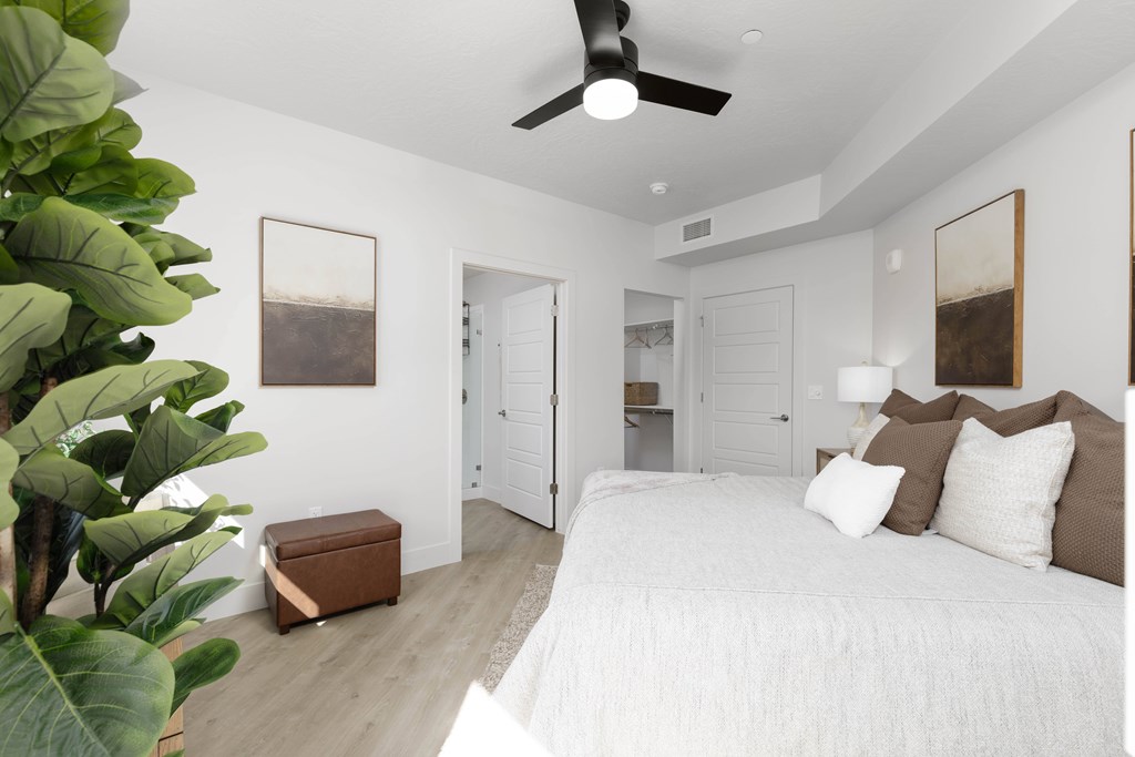 A bedroom with a large bed and a ceiling fan.