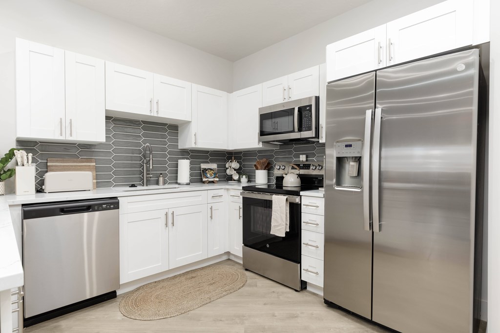 A modern kitchen with stainless steel appliances and white cabinets. at The Vue At Desert Color, St. George, UT, 84790
