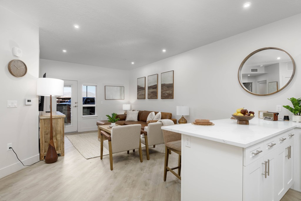 A modern kitchen with white cabinets and a wooden island. at The Vue At Desert Color, St. George, 84790