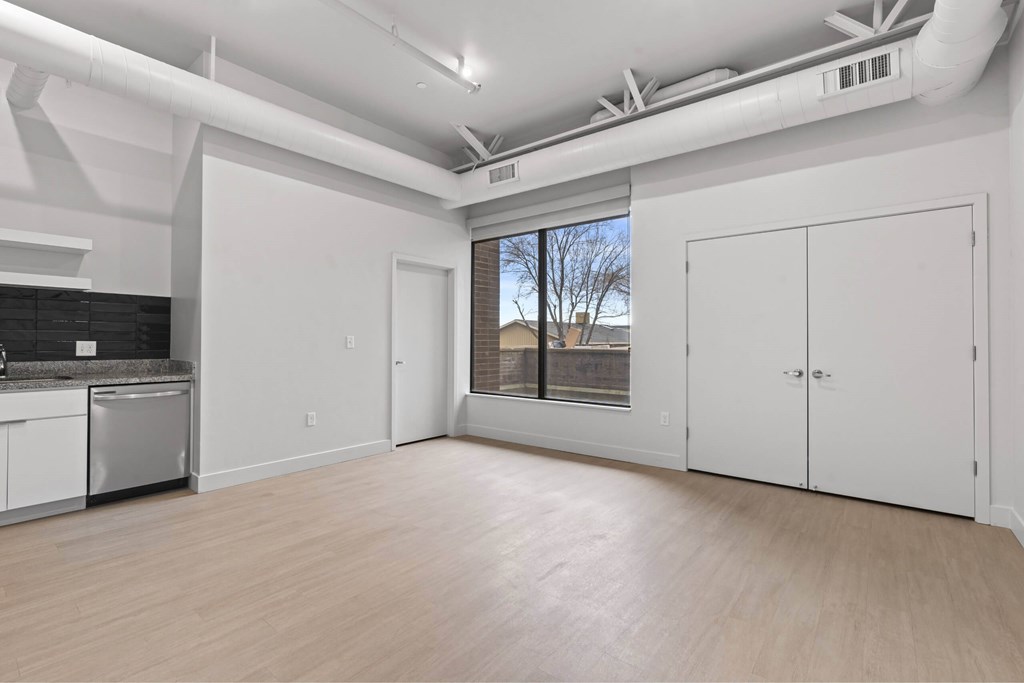 A large empty room with white walls and wooden flooring. at Brickside Heights, Millcreek, 84106