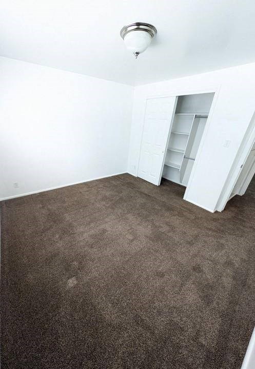 A room with a carpeted floor and a white ceiling with a light fixture.