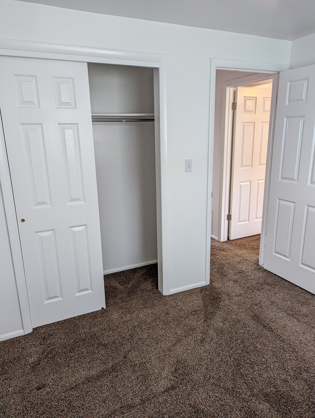 A white door is open to a hallway.