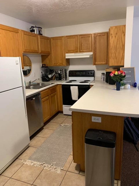 A kitchen with wooden cabinets and a white refrigerator.